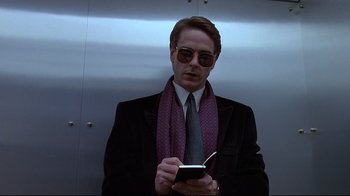 Movie still from “Dead Ringers” (1988), directed by David Cronenberg – A man in a suit and tie holding a cell phone; Close Up shot, Low angle