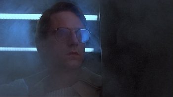 Movie still from “Dead Ringers” (1988), directed by David Cronenberg – A man wearing glasses and a white shirt; Close Up shot, Low angle