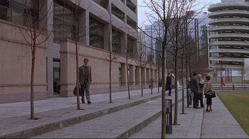 Movie still from “Dead Ringers” (1988), directed by David Cronenberg – A man walking down a sidewalk near a building; Extreme Wide shot, High angle