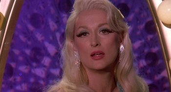 Movie still from “Death Becomes Her” (1992), directed by Robert Zemeckis – A person with long blonde hair; Close Up shot, Over the shoulder angle