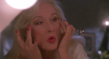 Movie still from “Death Becomes Her” (1992), directed by Robert Zemeckis – A person holding their hands up to their face; Close Up shot, High angle