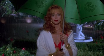 Movie still from “Death Becomes Her” (1992), directed by Robert Zemeckis – A woman holding an umbrella in the pouring rain; Close Up shot, Low angle