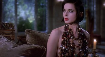 Movie still from “Death Becomes Her” (1992), directed by Robert Zemeckis – A woman sitting on a couch wearing a necklace; Close Up shot, Over the shoulder angle