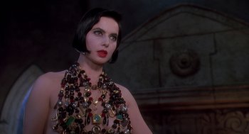 Movie still from “Death Becomes Her” (1992), directed by Robert Zemeckis – A woman with dark hair wearing a necklace; Close Up shot, Low angle
