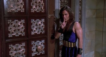 Movie still from “Death Becomes Her” (1992), directed by Robert Zemeckis – A man standing in front of an ornate door; Medium shot, Over the shoulder angle