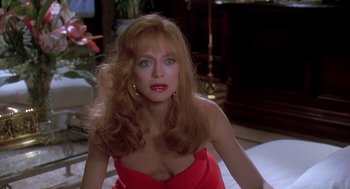 Movie still from “Death Becomes Her” (1992), directed by Robert Zemeckis – A woman in a red dress sitting on the floor; Close Up shot, Over the shoulder angle