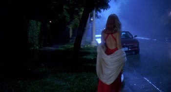 Movie still from “Death Becomes Her” (1992), directed by Robert Zemeckis – A woman in a red dress walking down a street; Wide shot, Low angle