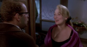 Movie still from “Death Becomes Her” (1992), directed by Robert Zemeckis – A woman in a purple jacket talking to a man in glasses; Medium shot, Over the shoulder angle