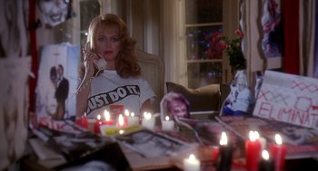 Movie still from “Death Becomes Her” (1992), directed by Robert Zemeckis – A woman sitting in front of candles on a table; Medium shot, Over the shoulder angle