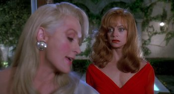 Movie still from “Death Becomes Her” (1992), directed by Robert Zemeckis – Two women in a red dress one of which is wearing pearls; Close Up shot, Over the shoulder angle