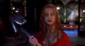 Movie still from “Death Becomes Her” (1992), directed by Robert Zemeckis – A woman holding a large metal object in her hand; Close Up shot, Low angle