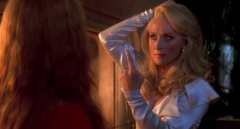 Movie still from “Death Becomes Her” (1992), directed by Robert Zemeckis – A woman in a white shirt is looking at herself in the mirror; Close Up shot, Over the shoulder angle