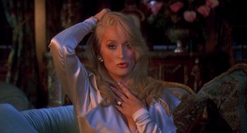Movie still from “Death Becomes Her” (1992), directed by Robert Zemeckis – A beautiful blonde haired woman in a white satin shirt; Close Up shot, Over the shoulder angle