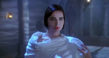 Movie still from “Death Becomes Her” (1992), directed by Robert Zemeckis – A woman in a white dress is posing for a picture; Close Up shot, Low angle