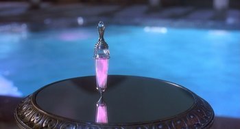 Movie still from “Death Becomes Her” (1992), directed by Robert Zemeckis – A pink liquid is sitting on top of a black table; Extreme Close Up shot, High angle