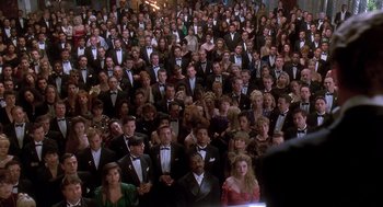Movie still from “Death Becomes Her” (1992), directed by Robert Zemeckis – A large group of people wearing tuxedos and bow ties; Wide shot, High angle
