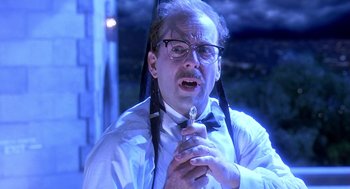 Movie still from “Death Becomes Her” (1992), directed by Robert Zemeckis – An old man with glasses holding a wrench in his hand; Close Up shot, Low angle