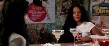 Movie still from “Death Proof” (2007), directed by Quentin Tarantino – A woman sitting at a table with two glasses of wine; Medium shot, Over the shoulder angle