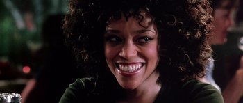 Movie still from “Death Proof” (2007), directed by Quentin Tarantino – A person with curly hair smiling; Close Up shot, Low angle