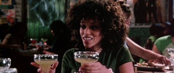 Movie still from “Death Proof” (2007), directed by Quentin Tarantino – A woman holding a drink in her hands; Close Up shot, Over the shoulder angle