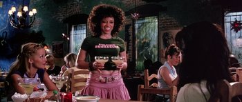 Movie still from “Death Proof” (2007), directed by Quentin Tarantino – A woman is holding a video game controller in her hands; Medium shot, Low angle