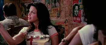 Movie still from “Death Proof” (2007), directed by Quentin Tarantino – A woman sitting at a table with a glass of wine; Close Up shot, Over the shoulder angle