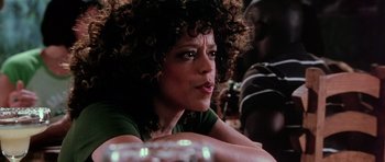 Movie still from “Death Proof” (2007), directed by Quentin Tarantino – A person sitting at a table; Close Up shot, Over the shoulder angle