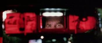 Movie still from “Death Proof” (2007), directed by Quentin Tarantino – A man looking into a mirror in a car; Extreme Close Up shot, Low angle