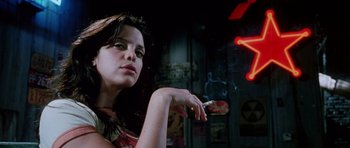 Movie still from “Death Proof” (2007), directed by Quentin Tarantino – A beautiful woman smoking a cigarette in front of a neon sign; Close Up shot, Low angle