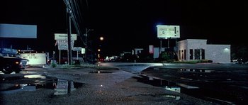 Movie still from “Death Proof” (2007), directed by Quentin Tarantino – A street at night that has a lot of water on the ground; Extreme Wide shot, Low angle