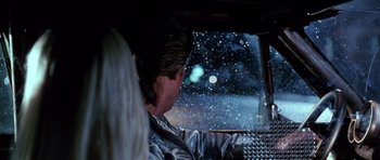 Movie still from “Death Proof” (2007), directed by Quentin Tarantino – A man sitting in the driver's seat of a car looking out the window; Close Up shot, Over the shoulder angle