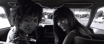 Movie still from “Death Proof” (2007), directed by Quentin Tarantino – Two young women sitting in the back seat of a car; Close Up shot, Over the shoulder angle