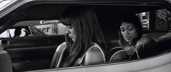 Movie still from “Death Proof” (2007), directed by Quentin Tarantino – A woman sitting in the back seat of a car; Close Up shot, Low angle