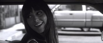 Movie still from “Death Proof” (2007), directed by Quentin Tarantino – A young woman smiling while sitting in a car; Close Up shot, Over the shoulder angle