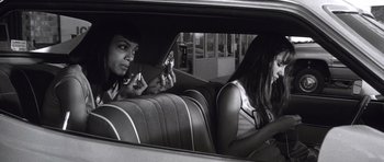 Movie still from “Death Proof” (2007), directed by Quentin Tarantino – Two women sitting in the back seat of a car; Medium shot, Low angle