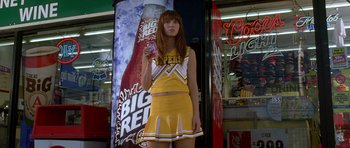 Movie still from “Death Proof” (2007), directed by Quentin Tarantino – A woman in a cheerleader outfit holding a soda; Medium shot, Low angle