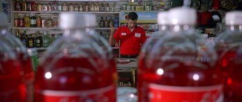 Movie still from “Death Proof” (2007), directed by Quentin Tarantino – A man standing behind a counter in a store; Medium shot, High angle