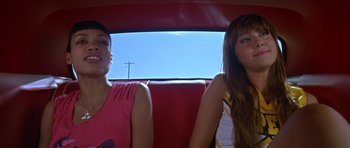 Movie still from “Death Proof” (2007), directed by Quentin Tarantino – Two women sitting in the back seat of a red car; Close Up shot, Low angle
