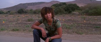 Movie still from “Death Proof” (2007), directed by Quentin Tarantino – A woman squatting on the side of a road; Medium shot, High angle