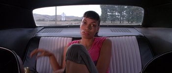 Movie still from “Death Proof” (2007), directed by Quentin Tarantino – A woman sitting in a car looking at the camera; Close Up shot, Over the shoulder angle