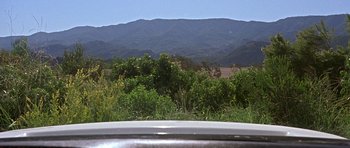 Movie still from “Death Proof” (2007), directed by Quentin Tarantino – A view from a car looking out at a mountain range; Extreme Wide shot, High angle
