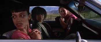 Movie still from “Death Proof” (2007), directed by Quentin Tarantino – A group of people sitting in the back of a car; Medium shot, Low angle