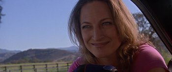 Movie still from “Death Proof” (2007), directed by Quentin Tarantino – A person smiling for the camera; Close Up shot, Low angle