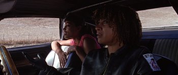 Movie still from “Death Proof” (2007), directed by Quentin Tarantino – Two people sitting in the back seat of a car; Close Up shot, High angle