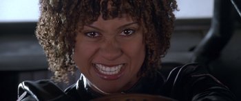 Movie still from “Death Proof” (2007), directed by Quentin Tarantino – A person with a smile on their face; Close Up shot, Low angle