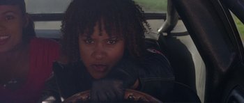 Movie still from “Death Proof” (2007), directed by Quentin Tarantino – A woman sitting in the driver's seat of a car; Close Up shot, Low angle