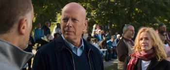 Movie still from “Death Wish” (2018), directed by Eli Roth – A man with a bald head is standing in front of a group of people; Close Up shot, Over the shoulder angle