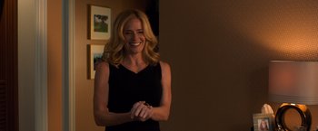 Movie still from “Death Wish” (2018), directed by Eli Roth – A woman smiles while standing in front of a wall; Medium shot, Over the shoulder angle