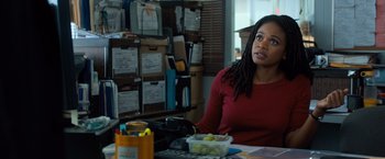 Movie still from “Death Wish” (2018), directed by Eli Roth – A woman sitting at a desk in front of a computer; Medium shot, Over the shoulder angle