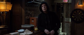 Movie still from “Death Wish” (2018), directed by Eli Roth – A man wearing a black hooded jacket standing in a kitchen; Medium shot, Over the shoulder angle